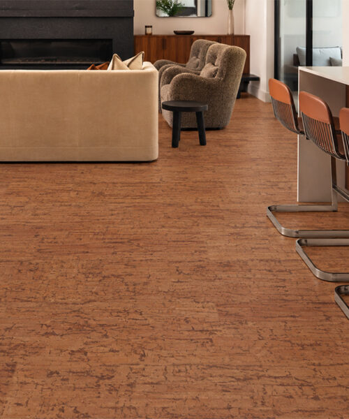 Warm Amber Amber Streak Cork Flooring Connects An Open Kitchen And Living Room With A Black Fireplace.