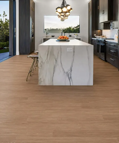 Wood-Look Cork Flooring Installed In A Modern Kitchen With A White Marble Island