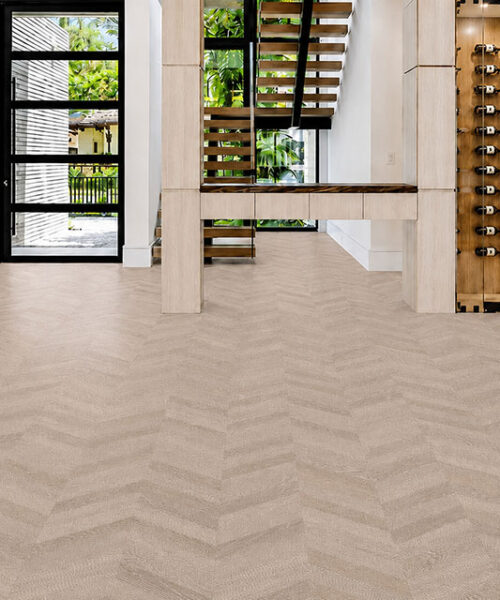 Light Gray Aurora Chevron Cork Flooring Spans An Entryway With A Floating Staircase And Illuminated Wine Display.