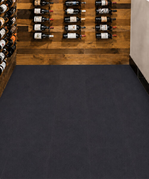 Black Buffalo Sustainable Leather Flooring In A Modern Wine Cellar With Dark Textured Planks, Wood Wine Racks And Floor-To-Ceiling Bottle Storage.