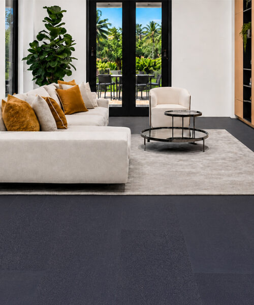 Eco-Friendly Black Buffalo Real Leather Flooring In A Bright Modern Living Room With Cream Sofa, Wood Media Cabinetry, Area Rug And Black-Framed Windows.