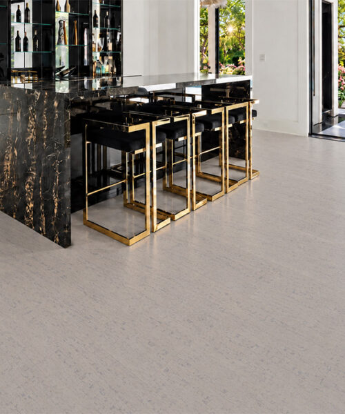 Bleached Birch 12mm off-white cork floor planks extend through a home bar with black marble island.