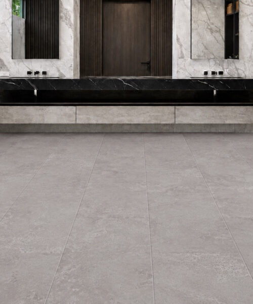 Bright Stone Swiss TechSlate flooring shows a pale gray stone-look surface with subtle mineral variation in a contemporary bathroom with a freestanding tub.