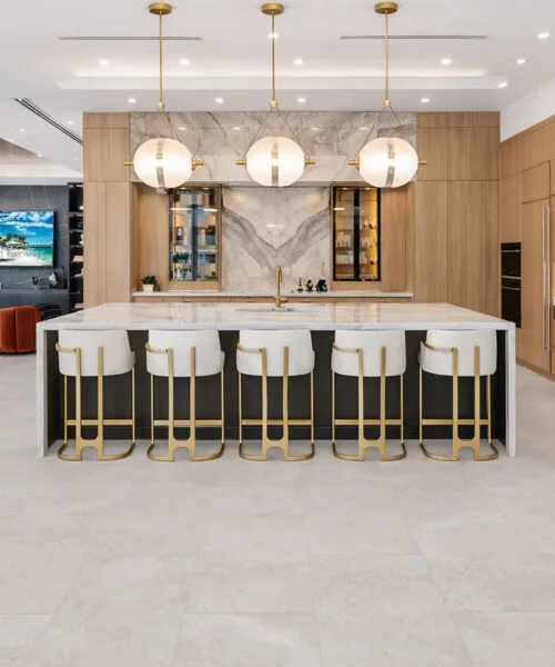 Bright Stone - 19/64&Quot; (7.5Mm) - Swiss Techslate (Mbrst7.5) Bright Stone Mineral-Based Flooring Forms A Softly Mottled Gray Surface Across A Contemporary Kitchen With A Large Island And Bar Seating.