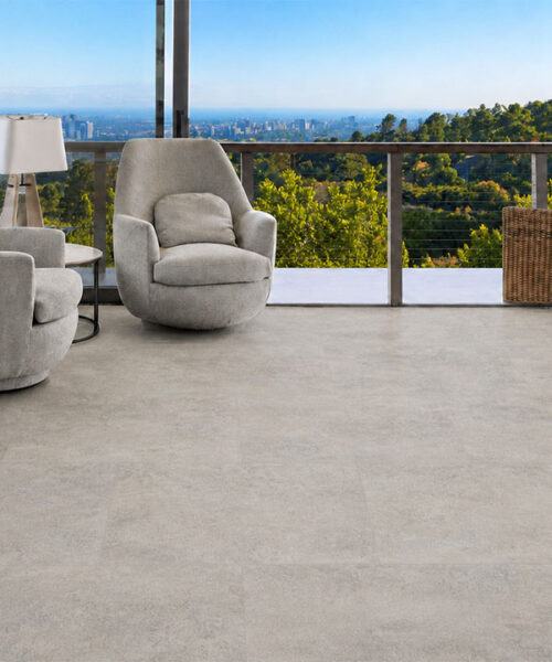 Bris Stone Pale Gray-Beige Floating Cork Flooring With Limestone Texture Spans An Ocean-View Lounge.