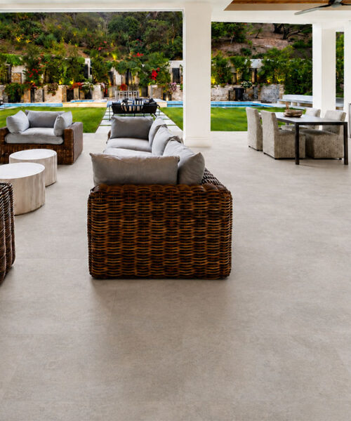Pale Gray Bris Stone Cork Floor Planks Connect Wicker Lounge Seating With A Poolside Dining Area.