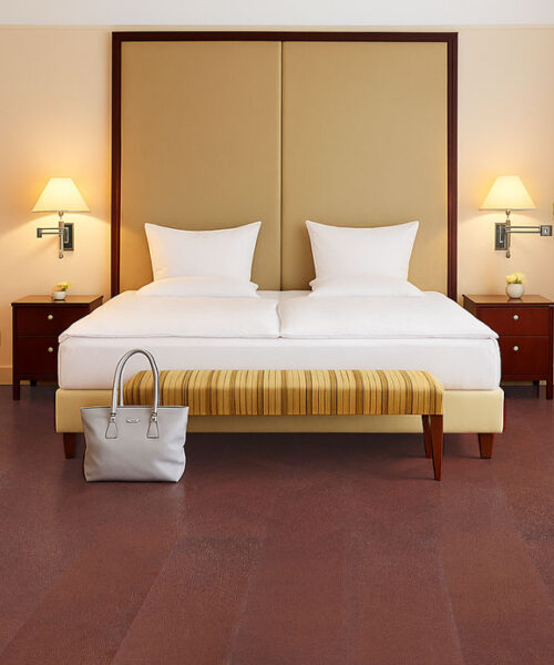 Chestnut Swiss Leather Flooring In A Hotel Style Bedroom With Golden Headboard And Striped Bench