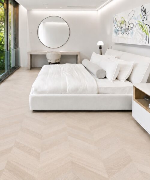 Clara Chevron Comfortable Cork Flooring Surrounds A White Bed In A Bright, Glass-Walled Bedroom With Garden Views.