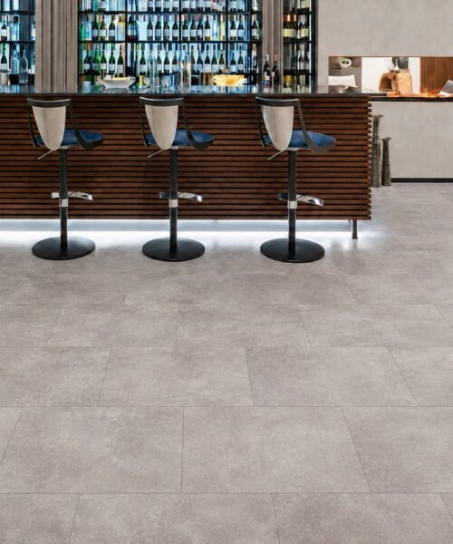 Copperstone Gray Natural Composite Flooring with gentle tonal variation spans a modern home bar and fireplace seating area.