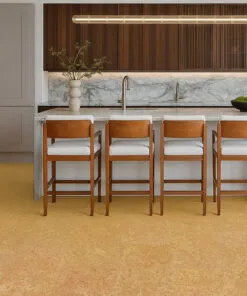 Luxury kitchen with marble waterfall island, wood slat cabinets, and bright Desert Arable cork flooring.