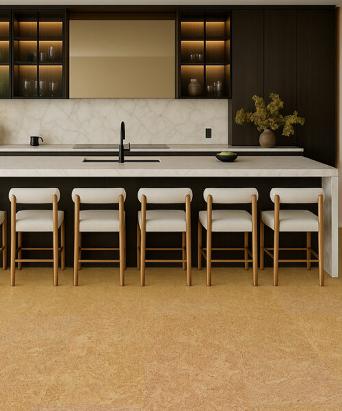 Contemporary Kitchen With Marble Island, Wooden Bar Stools, And Desert Arable Cork Flooring In A Soft Golden Tone.
