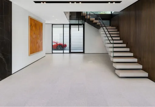 Contemporary Entryway With Floating Staircase, Glass Railing, And Light Grano Cork Flooring Enhancing The Spacious Modern Aesthetic.