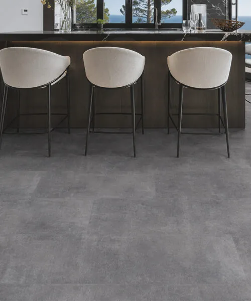 Concrete gray Forna Natural Composite flooring beneath a modern kitchen island and breakfast bar
