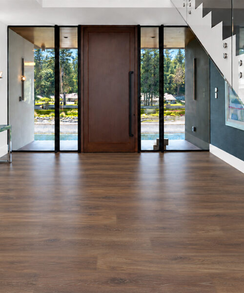 Latte - 7/16&Quot; (11Mm) - Swiss Design Cork Floating (Flat11) Comfortable Latte Wood-Grain Cork Floating Flooring In A Modern Entryway With A Glass Staircase, Wood Front Door, And Floor-To-Ceiling Windows.
