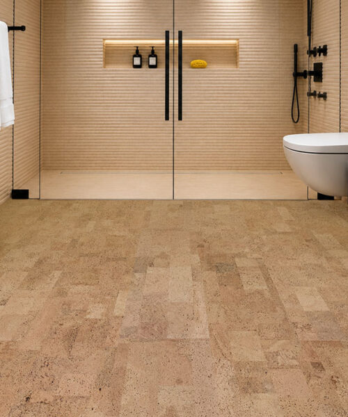 Leather Natural 6mm glue-down cork tile flooring in a luxury bathroom with a frameless glass shower, modern black vanity, and sealed natural cork floor.