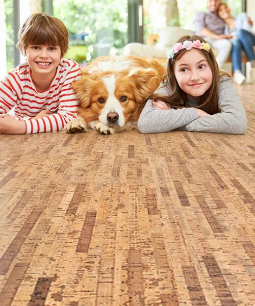 Family-friendly living space with children and dog enjoying Linea Dark Swiss Real Cork Floating Flooring's comfort and warmth.