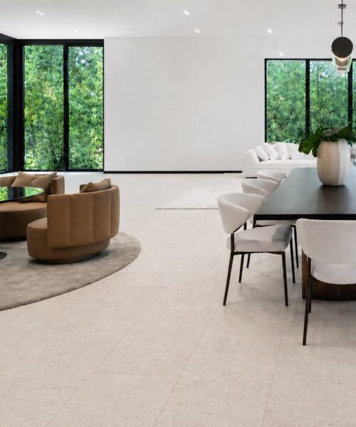 Matera Blend - 19/64&Quot; (7.5Mm) - Swiss Techslate (Mmatbd7.5) Light Limestone Matera Blend Stone-Look Flooring Extends Beneath A Kitchen Island And Into A Modern Living Room.