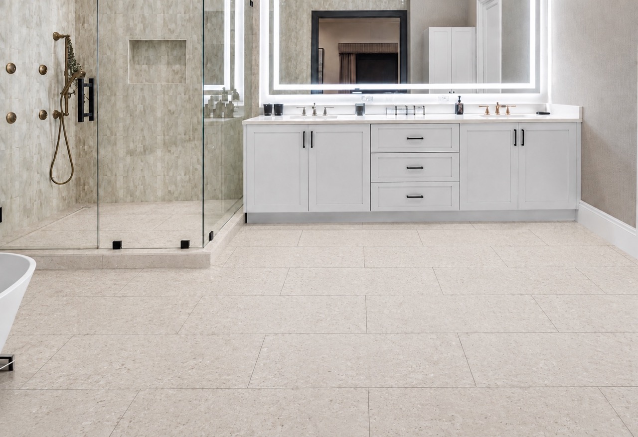 Matera Blend - 19/64&Quot; (7.5Mm) - Swiss Techslate (Mmatbd7.5) Matera Blend Mineral-Based Flooring In Light Limestone Features Subtle Printed Variation Beneath A White Bathroom Vanity And Glass Shower.