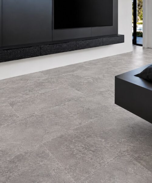 Midnight Slate Techslate Flooring Creates A Gray Slate-Look Floor In A Contemporary Bedroom With A Black Media Wall, Platform Bed, And Pool View.