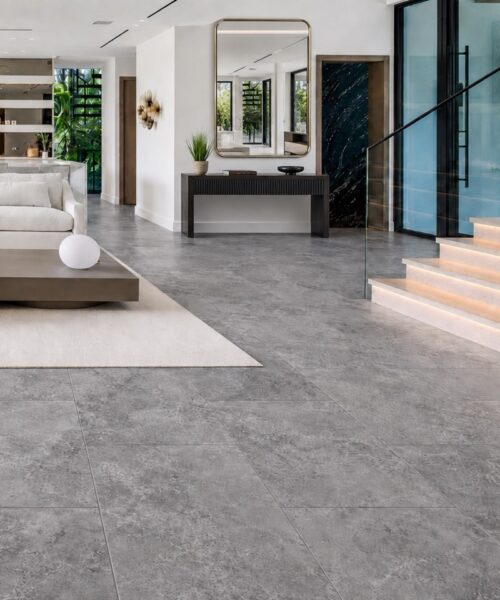 Midnight Slate slate-look flooring unifies the living room, kitchen, and stair hall with large gray mineral-patterned planks.