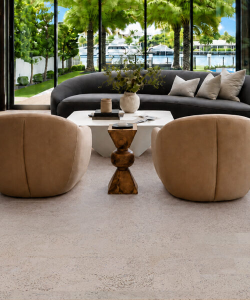 Mystic Vanilla Swiss Real Cork Floating Flooring In A Waterfront Living Room With Curved Seating And Pool Views.