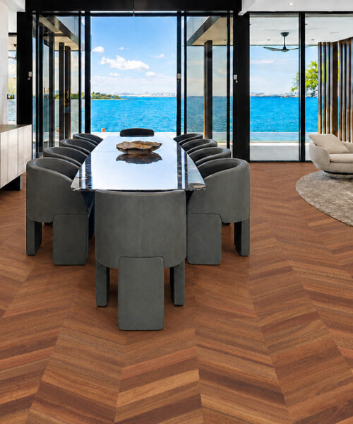 Noble Chevron Wood-Look Cork Flooring Covers An Ocean-View Dining Room With Gray Chairs And Glass Doors.