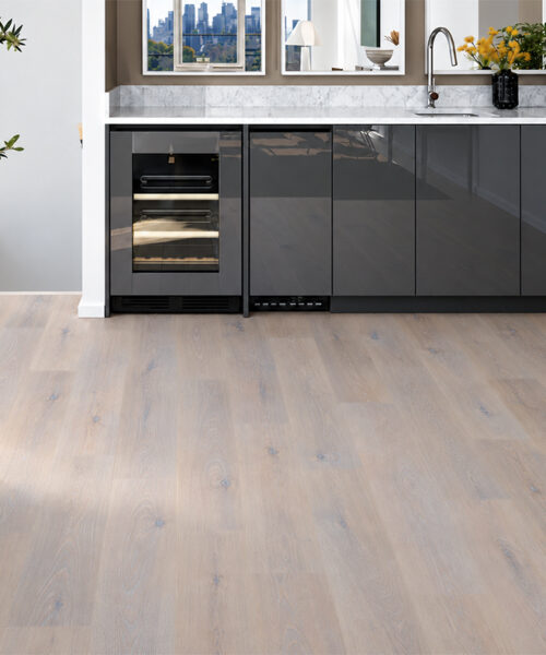 Nordic Oak - 3/8&Quot; (9.5Mm) - Forna Natural Composite Flooring With Waterproof Hydrowood Core (Nnoro9.5) Nordic Oak Natural Composite Click-Lock Flooring Shows Pale Gray Oak Grain Beside A Black-Cabinet Home Bar.