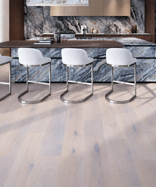 Nordic Oak - 3/8&Quot; (9.5Mm) - Forna Natural Composite Flooring With Waterproof Hydrowood Core (Nnoro9.5) Nordic Oak Pale Gray Wood-Look Natural Composite Flooring Surrounds A Marble Kitchen Island With White Bar Stools.
