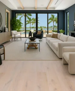 Luxurious living room showcasing Nordic Oak Swiss Real Linoleum Floating Flooring in soft natural oak color, paired with modern beige furniture and large windows overlooking a pool and palm trees.