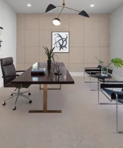Modern Minimalist Home Office Featuring Porto Mist Swiss Natural Cork Flooring. The Room Includes A Dark Wood Desk With A Brass Base, A Brown Leather Office Chair, Two Black Leather Guest Chairs With Chrome Frames, And A Geometric Light Fixture Overhead. A Large Window Brings In Natural Light, Highlighting The Soft Beige Tones Of The Cork Floor And Matching Cork Wall Panels For A Cohesive, Contemporary Look.