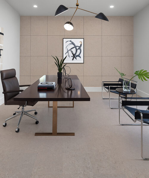 Porto Mist - 7/16&Quot; (11Mm) - Swiss Real Cork Floating (Fpm11) Modern Minimalist Home Office Featuring Porto Mist Swiss Natural Cork Flooring. The Room Includes A Dark Wood Desk With A Brass Base, A Brown Leather Office Chair, Two Black Leather Guest Chairs With Chrome Frames, And A Geometric Light Fixture Overhead. A Large Window Brings In Natural Light, Highlighting The Soft Beige Tones Of The Cork Floor And Matching Cork Wall Panels For A Cohesive, Contemporary Look.