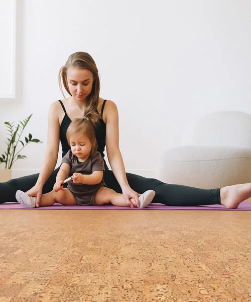 Mother And Child Stretching On Yoga Mat In Bright Room With Natural Quodro Swiss Cork Flooring. Pinterest Title: Family Yoga On Swiss Cork Floors