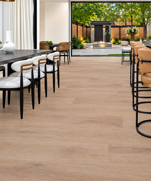 Sandstorm - 7/16&Quot; (11Mm) - Swiss Design Cork Floating (Fsan11) Sustainable Sandstorm Cream-Tan Cork Flooring In An Open Kitchen And Dining Area With A Black Marble Island And Garden Patio.