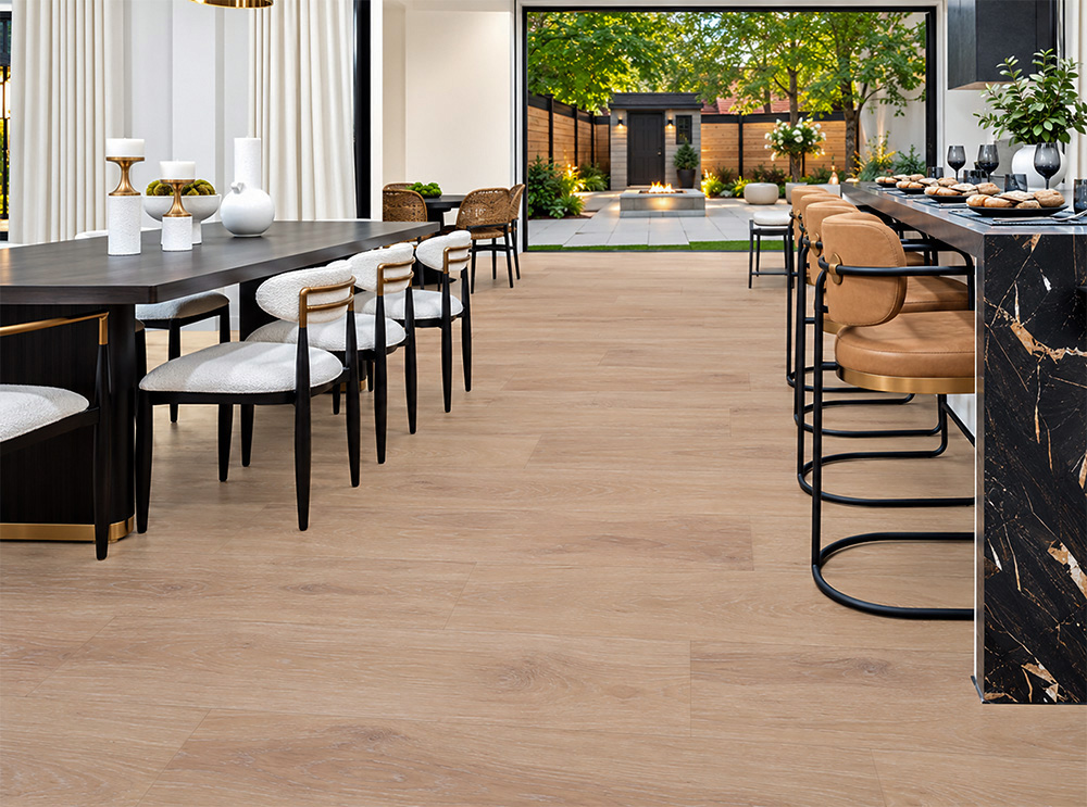 Sandstorm - 7/16&Quot; (11Mm) - Swiss Design Cork Floating (Fsan11) Sustainable Sandstorm Cream-Tan Cork Flooring In An Open Kitchen And Dining Area With A Black Marble Island And Garden Patio.