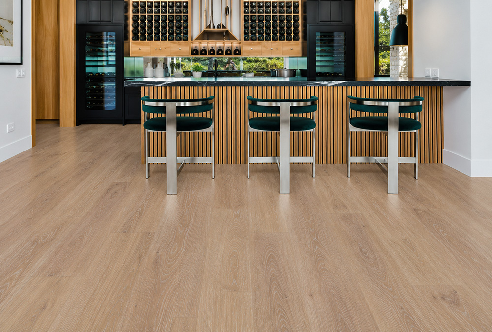 Sandstorm - 7/16&Quot; (11Mm) - Swiss Design Cork Floating (Fsan11) Sandstorm Light-Beige Wood-Grain Cork Floating Flooring In A Luxury Home Wine Bar With Bottle Storage, Wine Coolers, And A Slatted Island.