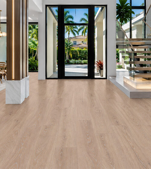 Sandstorm - 7/16&Quot; (11Mm) - Swiss Design Cork Floating (Fsan11) Sustainable Sandstorm Hardwood-Look Cork Flooring In An Open Modern Entryway With Tropical Views, An Adjacent Dining Area, And Glass Staircase.