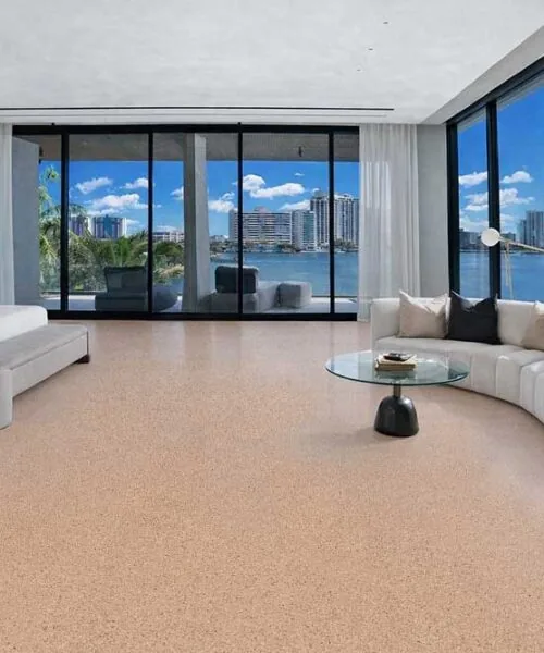 Luxury waterfront bedroom featuring Seaside cork flooring with natural warm tones and floor-to-ceiling ocean views.