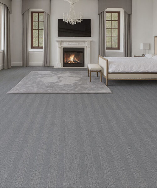 Elegant Bedroom With Serpent Luxe Forna Swiss Leather Floating Flooring, Gray Patterned Design Adding Modern Luxury Under A Cozy Fireplace Setting.