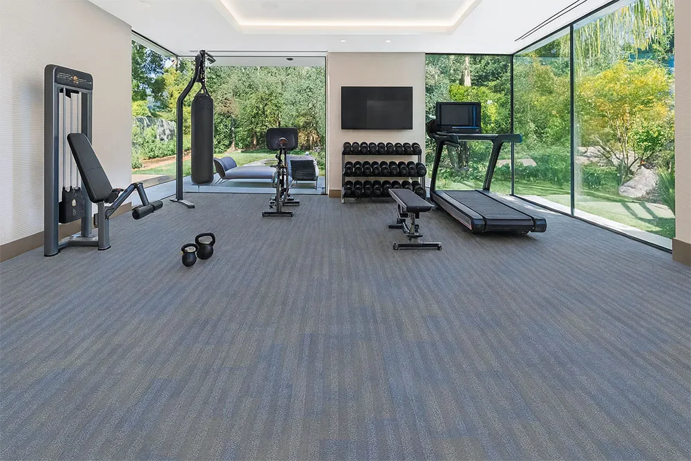 Home Gym With Serpent Luxe Forna Swiss Leather Flooring, Durable Floating Planks In Blue-Gray Tones, Complementing Fitness Equipment And Large Glass Windows.