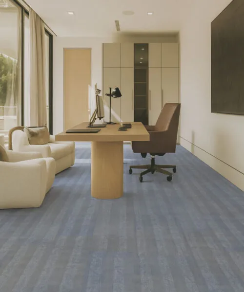 Home Office With Serpent Luxe Forna Swiss Luxury Leather Floating Flooring, Soft Blue-Gray Tones Adding Durability And Elegance Under A Desk And Lounge Chairs.