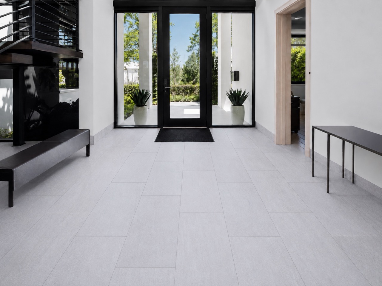 Snowstone - 19/64&Quot; (7.5Mm) - Swiss Techslate (Mcsnows7.5) Snowstone Click-Lock Flooring Features Pale Gray Mineral Texture In A Modern Entryway With Black-Framed Doors, A Bench, And Console Table.