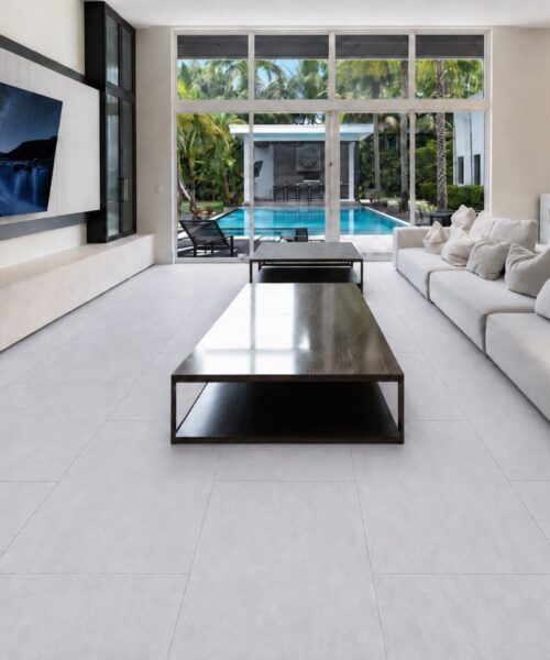 Snowstone - 19/64&Quot; (7.5Mm) - Swiss Techslate (Mcsnows7.5) Snowstone Large-Format Stone-Look Flooring Extends Across A Bright Living Room With White Sofas, A Dark Coffee Table, And Pool Views.