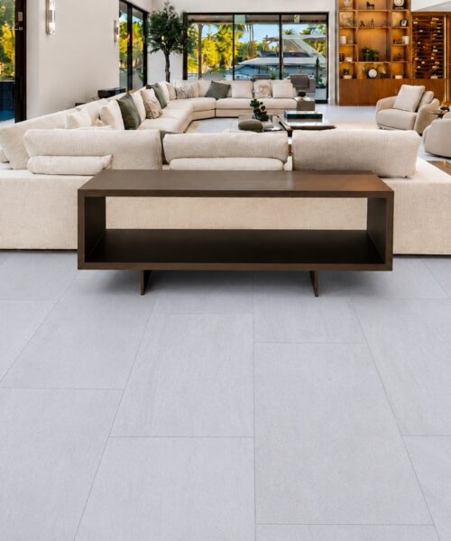 Snowstone - 19/64&Quot; (7.5Mm) - Swiss Techslate (Mcsnows7.5) Snowstone Techslate Flooring In A Pale Gray Mineral Pattern Anchors A Spacious Living Room With Sectional Seating And Dark Wood Furniture.