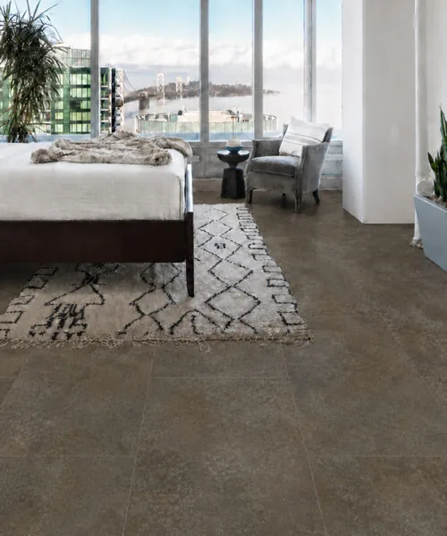 Sunlit Stone - 19/64&Quot; (7.5Mm) - Swiss Techslate (Msunst7.5) Sunlit Stone Brown-Gray Stone-Look Flooring In A Modern Bedroom With Floor-To-Ceiling Windows