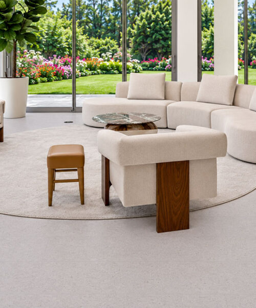 Sustainazzo Floating Cork Flooring Surrounds A Curved Cream Sofa In A Bright Garden-View Living Room.