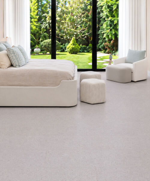 Sustainazzo White Floating Cork Flooring With Subtle Speckling In A Bright Garden-View Bedroom.