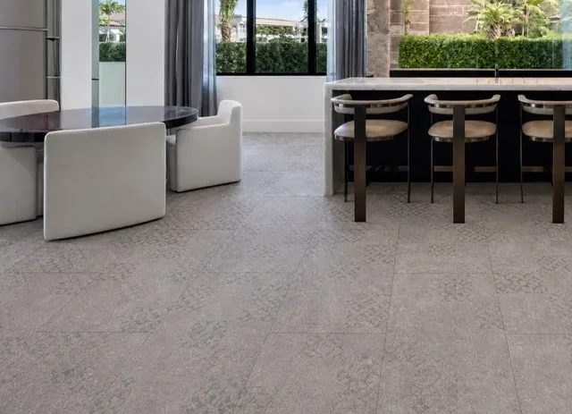 Vintage Stone - 19/64&Quot; (7.5Mm) - Swiss Techslate (Mvinst7.5) Vintage Stone Swiss Techslate Gray Stone-Look Floating Flooring In An Open-Concept Luxury Kitchen With Marble Island.