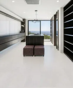 Spacious walk-in closet with built-in cabinetry and white leather cork flooring for a bright, clean modern look.