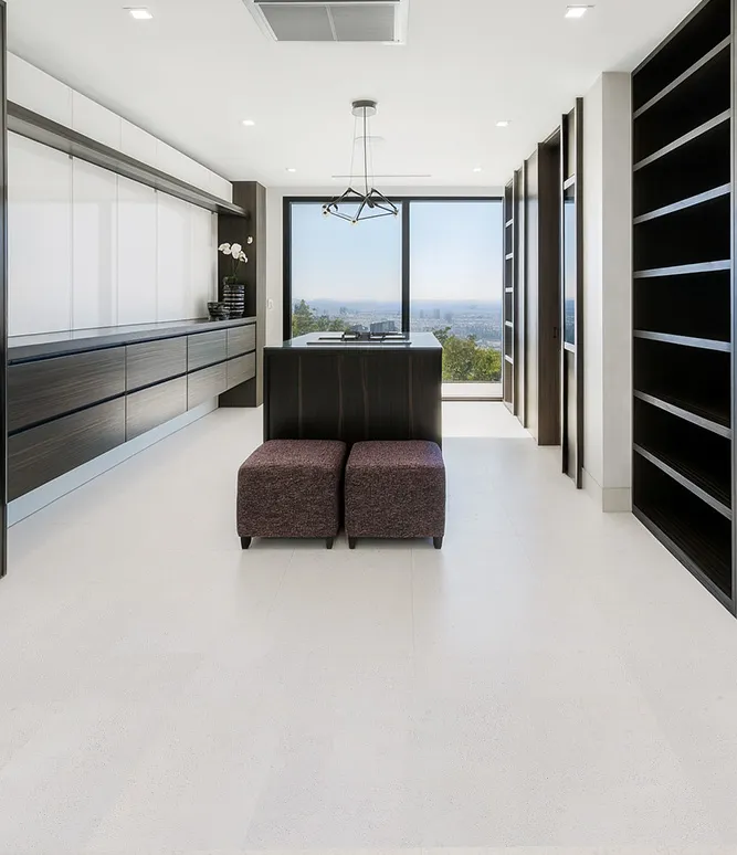 Spacious Walk-In Closet With Built-In Cabinetry And White Leather Cork Flooring For A Bright, Clean Modern Look.