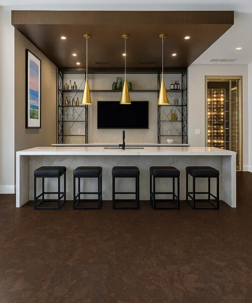 Walnut Burlwood cork flooring installed in a stylish bar and entertainment room with gold pendant lights and stools.